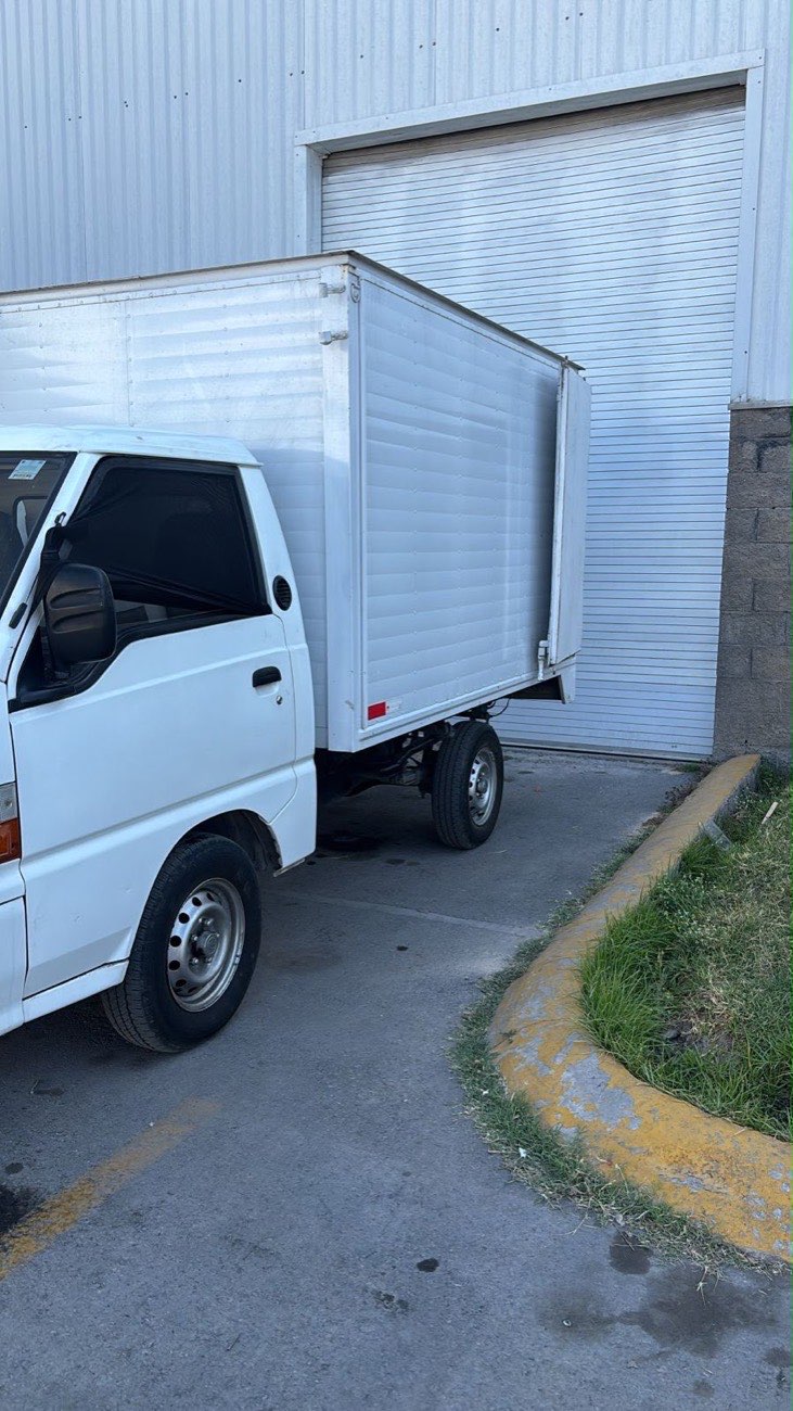 Unidad de RLC Express cargando mercancía en el andén de una bodega